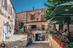 un grupo de personas caminando por una calle con una tienda en Villa entière. Alpilles Aix Marseille Avignon., en Istres