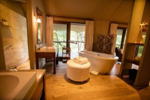 a bathroom with a large tub and a sink and a tub at Kapama Buffalo Camp in Kapama Private Game Reserve