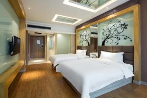 Un dormitorio con dos camas y una pared con un mural de flores. en Morninginn, Xinhua Railway Station, en Xinhua