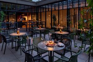 an outdoor patio with tables and chairs and a restaurant at U Parkhotel in Enschede