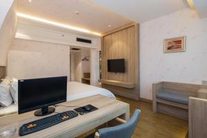 a hotel room with a bed and a desk with a computer at Morninginn, Xinhua Railway Station in Xinhua