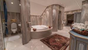 a large bathroom with a tub and a toilet at Villa Bostele with Seven Bedrooms, Indoor Pool and Two Saunas in Bad Kleinkirchheim
