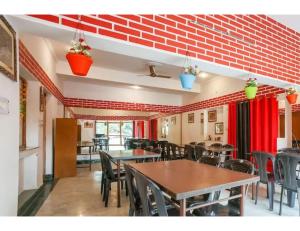 een restaurant met tafels en stoelen en rode muren bij Hotel SJ Residency, Dehradun in Dehradun