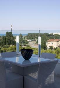 un tavolo con sedie e una ciotola sul balcone di Suite Luxury Seaview a Misano Adriatico