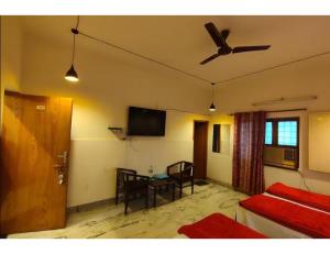 een kamer met een bed en een plafondventilator bij Hotel SJ Residency, Dehradun in Dehradun