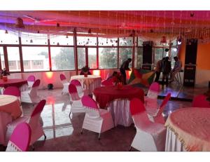 een kamer met roze en witte stoelen en tafels bij Hotel SJ Residency, Dehradun in Dehradun