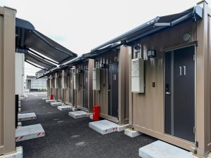 una fila de edificios modulares en un estacionamiento en HOTEL R9 The Yard Kasai, en Kasai