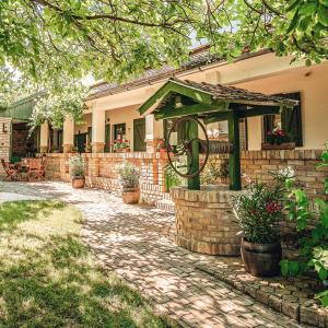 a house with a stone patio with a gazebo at Provence Birtok in Decs