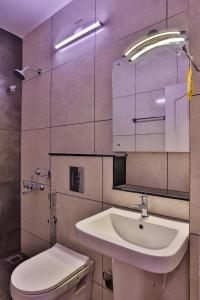 ein Badezimmer mit einem Waschbecken, einem WC und einem Spiegel in der Unterkunft IVY RESIDENCY in Thiruvananthapuram