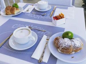 a table with a cup of coffee and a pastry with a lime at Butiko in Castelluzzo