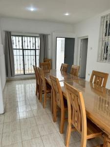 uma sala de jantar com uma grande mesa de madeira e cadeiras em Villa 471 m2 sur la plage em Mohammedia