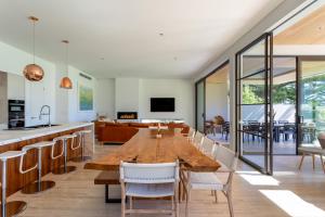 Un comedor con una larga mesa de madera y sillas. en Flametree I Private Properties, en Dunsborough