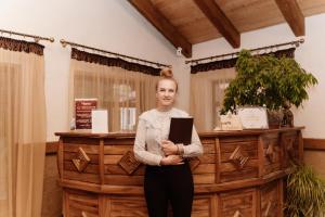 a woman standing in front of a counter with a laptop at Oksamit Resort in Vorokhta