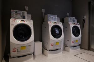 three washing machines are lined up in a room at THE BLOSSOM KYOTO in Kyoto