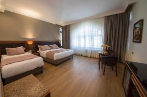 una camera d'albergo con due letti e un tavolo di Vardar Palace Hotel - Special Category a Istanbul