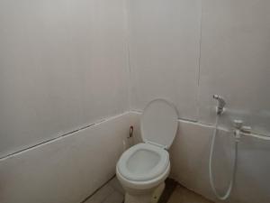 a bathroom with a white toilet and a shower at Tupi's Beachfront Home 2BR in Bacungan