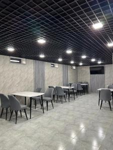 ein Zimmer mit Tischen und Stühlen in einem Gebäude in der Unterkunft ReveL HoteL in Taschkent
