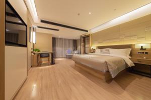 a hotel room with a bed and a desk and a room at Morning Hotel, Wuxi Jiangnan University Sunac Cultural Tourism City in Wuxi +20 photos