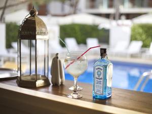 uma garrafa de álcool e um copo sobre uma mesa em Hotel Els Pins em Platja d'Aro