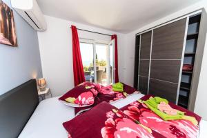 Schlafzimmer mit einem Bett mit roter Bettwäsche und einem Fenster in der Unterkunft Apt2 - Villa two Angels with swimming pool, Ika - Opatija in Ika