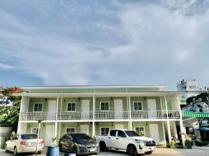 ein weißes Gebäude mit davor geparkt in der Unterkunft บ้านวิรา ห้องพัก Baan Wira in Khon Kaen