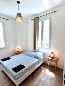 une chambre blanche avec un lit et deux fenêtres dans l'établissement Résidence Petite Californie, à Nice 29 autres photos