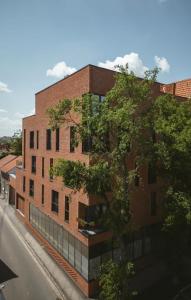 a brick building with a tree in front of it at 26Bricks Luxury Suites in Oradea