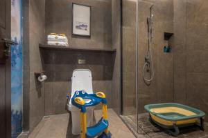 ein Bad mit einer Dusche, einem WC für Kinder und einem Spielzeug in der Unterkunft Till Bright Hotel, Changsha Yanghu University of Traditional Chinese Medicine in Changsha