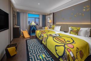 ein Hotelzimmer mit einem großen Bett mit gelber Bettwäsche in der Unterkunft Till Bright Hotel, Changsha Yanghu University of Traditional Chinese Medicine in Changsha