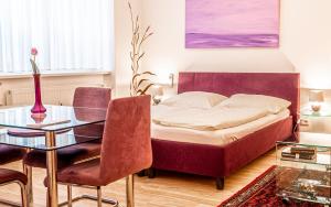 a bedroom with a bed and a table and chairs at Central Apartments Vienna - CAV in Vienna