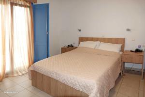 um quarto com uma cama grande e uma porta azul em Aerikohotel - Apartments em Agía Marína