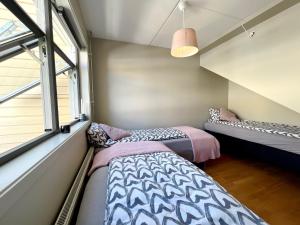 a bedroom with two beds and a window at City center flat w roof top terrace & free parking in Oslo