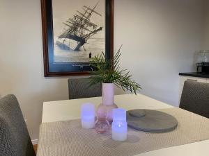 a table with candles and a vase with a plant at The Sounds in Murdunna