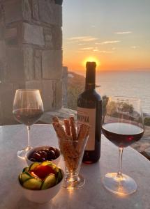 un tavolo con due bicchieri di vino e una bottiglia di vino di SYROU LOTOS Studios & Apartments a Kinion