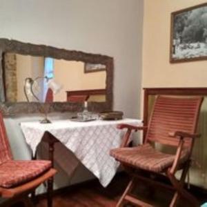 ein Zimmer mit einem Tisch, zwei Stühlen und einem Spiegel in der Unterkunft Yono's Traditional House in Áno Ravénia
