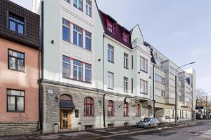 a white building with red windows on a street at Tempus Te Avangard Tallinn with terrace and gym in Tallinn