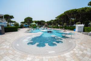 uma piscina num resort com mesas e cadeiras em Glamping Cavallino em Cavallino-Treporti