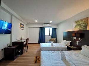 a hotel room with two beds and a desk at Ming Greenage Suite 明绿时代套房 @Kota Kinabalu 亚庇市中心 in Kota Kinabalu