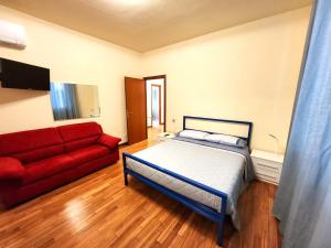 a bedroom with a bed and a red couch at Appartamento Noris in La Spezia