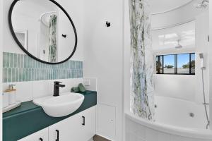 a bathroom with a sink and a mirror at Sun Drenched Unit in Noosaville in Noosaville +21 photos