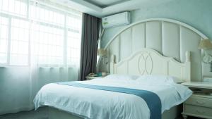 um quarto com uma grande cama branca e uma janela em Morninginn, Yanling Jinggang Road em Ling