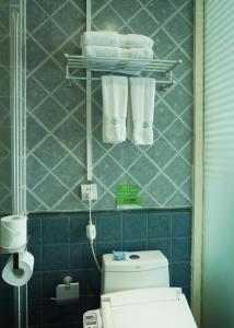 a bathroom with a toilet and towels on a wall at Morninginn, Yanling Jinggang Road in Ling