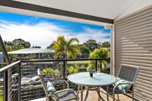 a patio with a table and chairs on a balcony at Sun Drenched Unit in Noosaville in Noosaville