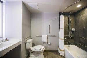 a bathroom with a toilet and a sink and a shower at Courtyard by Marriott Chicago at Medical District-UIC in Chicago