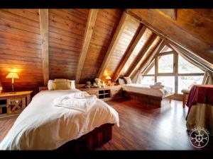 een slaapkamer met 2 bedden in een houten hut bij MULLERES de Alma de Nieve in Arties