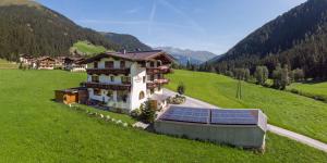 a house with solar panels on a green field at Haus Marchegg in Tux