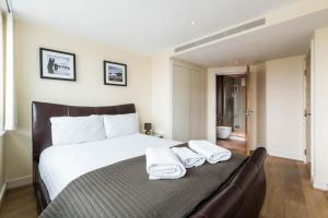 a bedroom with a bed with two towels on it at Luxury modern 2BD flat in centre in London