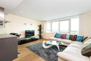uma sala de estar com um sofá e uma televisão em Luxury modern 2BD flat in centre em Londres