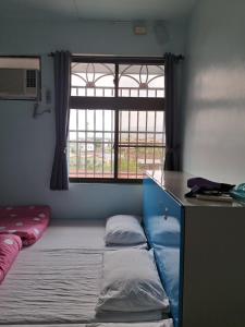 a small room with a bed and a window at 蘇馬利萬巒民宿 in Wanluan