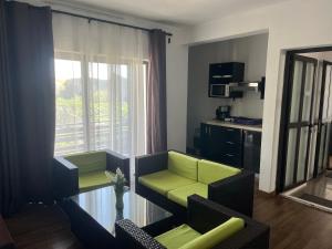 a living room with a couch and chairs and a window at Le Binome in Grand-Baie